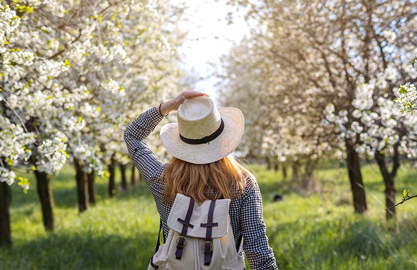 Woman wearing a hat in an orchard