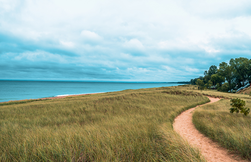 Dramatic landscape of lake michigan dunes and beach in New Buffalo Michigan. Sandy foot path leading to the beach before it rains.
